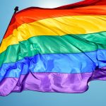 Rainbow flag on clear sky symbol of tolerance and acceptance - HospitalityLawyer.com®