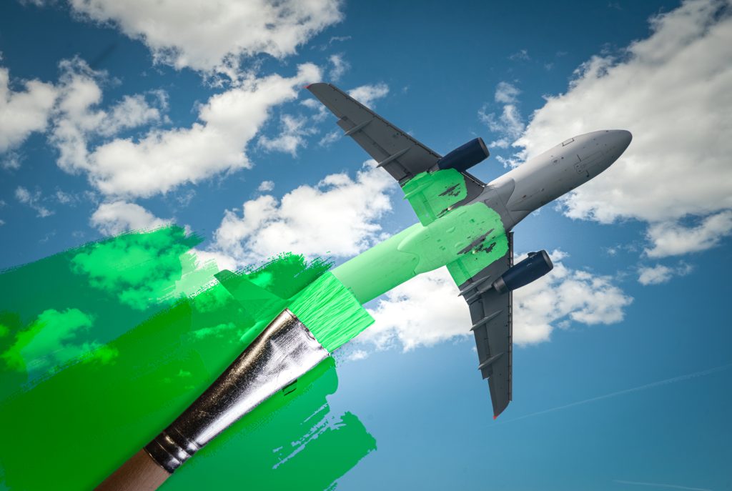 brush painting green an aircraft Greenwashing malpractice Zero emissions SAF or Sustainable Aviation Fuel and biofuel concepts - HospitalityLawyer.com® brush painting green an aircraft. Greenwashing malpractice, Zero emissions, SAF or Sustainable Aviation Fuel, Circular economy, net CO2 emissions or biofuel concepts.