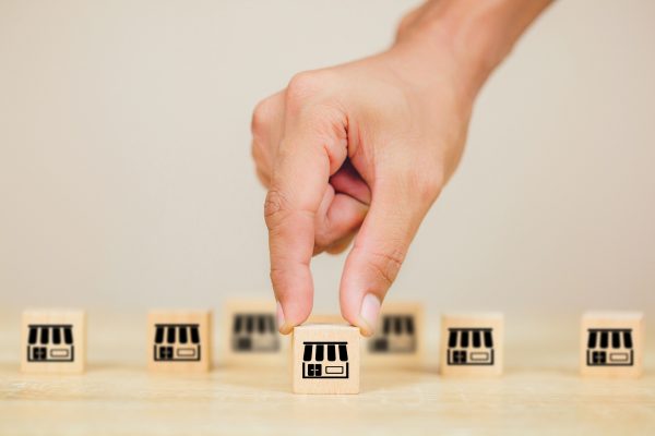 Franchise business concept, businessman hand choose wood blog with franchise marketing.