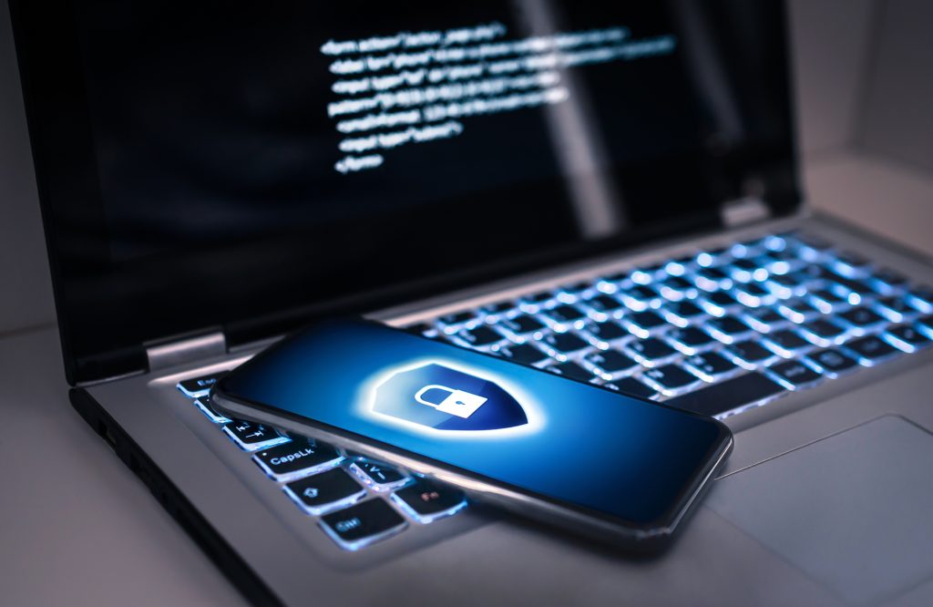 Phone lock to protect from cyber scam online data fraud or identity theft Laptop with hacker virus code in screen Phishing cybersecurity danger or ransomware attack - HospitalityLawyer.com® Protecting Your Digital Privacy: Practices, Tools, and Using Professional Security