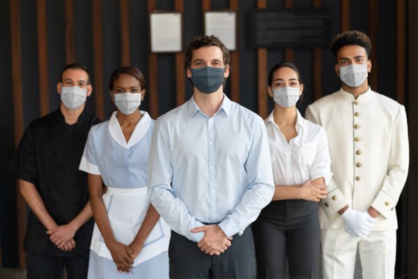 Staff working at a hotel wearing facemasks during the COVID-19 pandemic - reopening of businesses