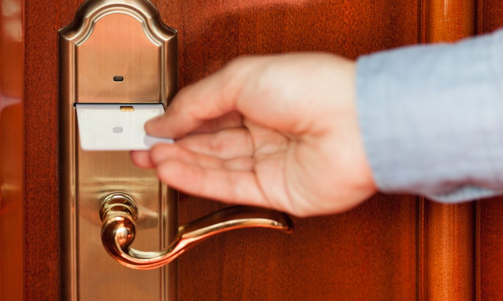 Man using a key card to enter a hotel room.