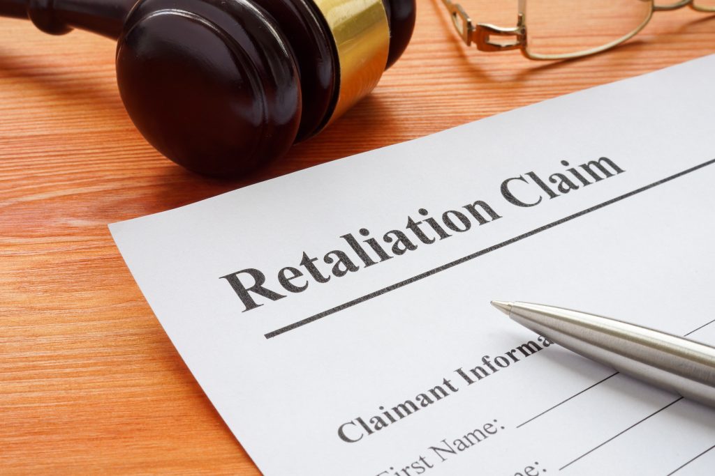 Retaliation claim lying on the desk with gavel - HospitalityLawyer.com® Retaliation claim lying on the desk with gavel.