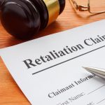 Retaliation claim lying on the desk with gavel - HospitalityLawyer.com® Retaliation claim lying on the desk with gavel.