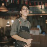 asian chinese teenage boy waiter looking at camera smiling work at cafe opening - HospitalityLawyer.com®