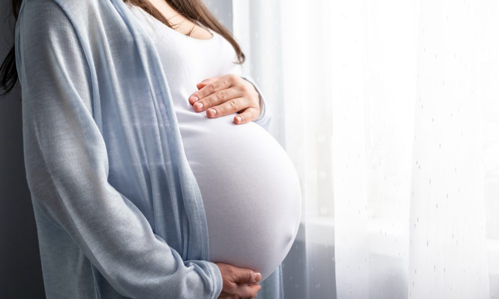 Side view pregnant woman with big belly advanced pregnancy in hands. Banner copyspace for text. Elegant mother waiting baby