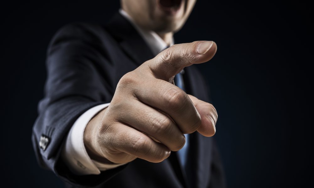 Businessman sticks out a finger and reproves it.