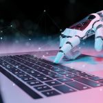 Robotic hand pressing a keyboard on a laptop 3D rendering - HospitalityLawyer.com® Robotic hand pressing a keyboard on a laptop 3D rendering