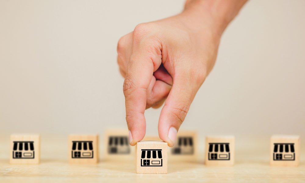 Franchise business concept , businessman hand choose wood blog with franchise marketing.