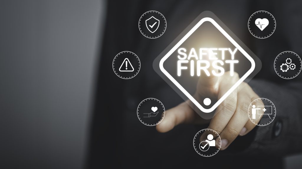 Work safety concept Businessman touching Safety first text Safety first sign on virtual screen Hazards protections regulations and insurance Zero accidents Protection dangerous - HospitalityLawyer.com®