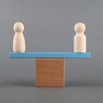 Man and woman figure on a scale Gender equality concept - HospitalityLawyer.com®