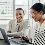 Business women laptop and and happy team in office for web design collaboration and training Planning digital marketing and coaching by woman leader menor help explain and support creative goal - HospitalityLawyer.com®