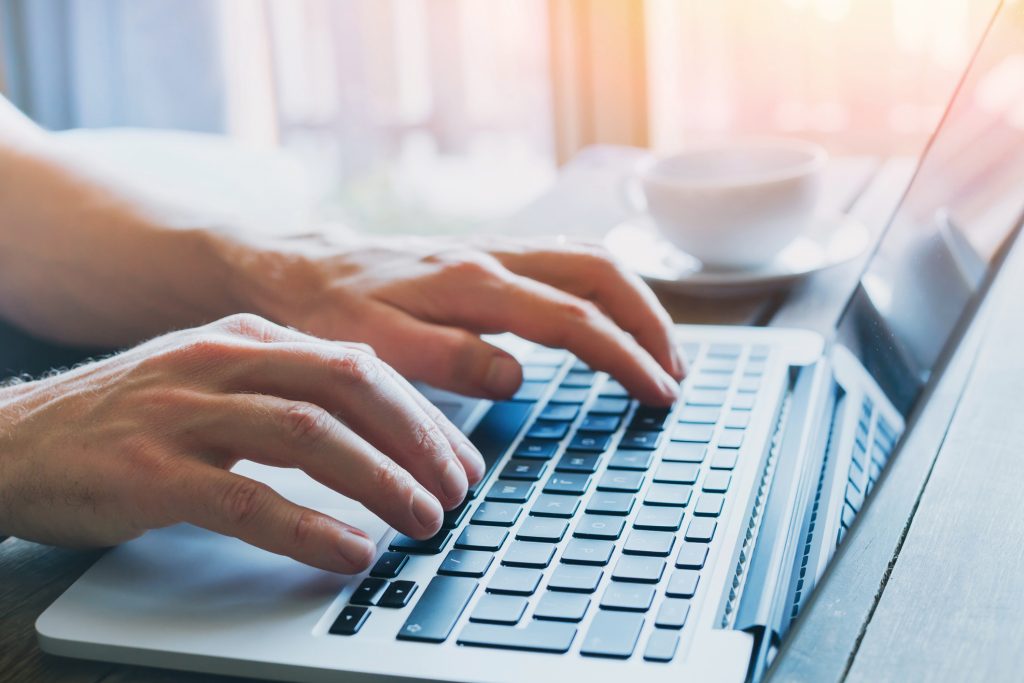 hands of business person working on computer - HospitalityLawyer.com®