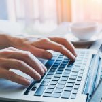 hands of business person working on computer - HospitalityLawyer.com®