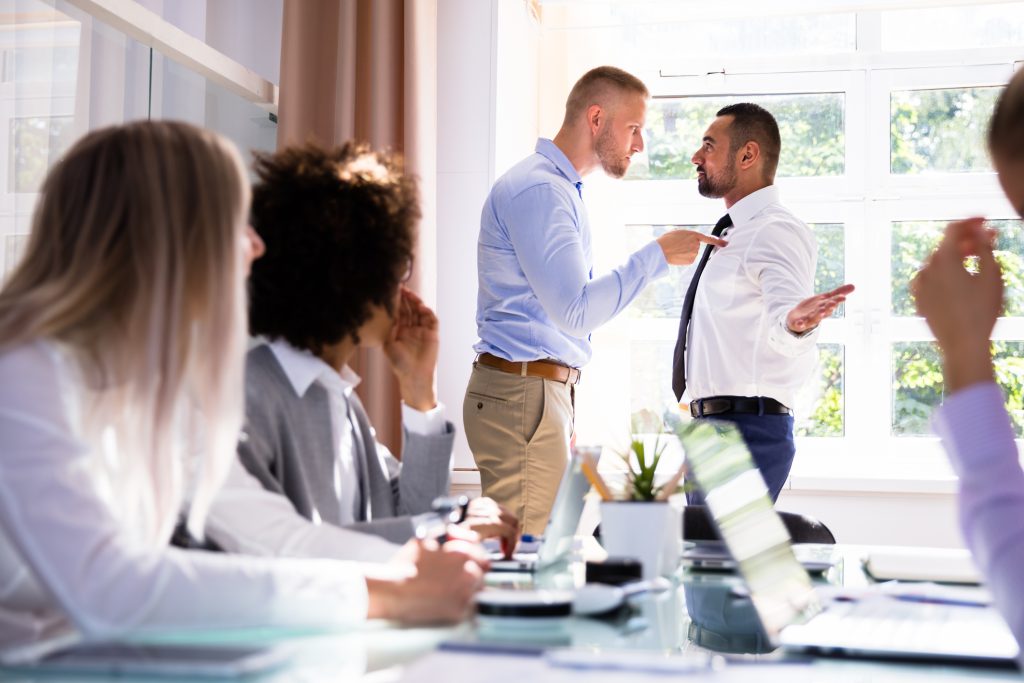 Two Male Colleagues Fighting In Office - HospitalityLawyer.com®