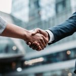 Meeting success Two business persons shaking hands standing outside - HospitalityLawyer.com®