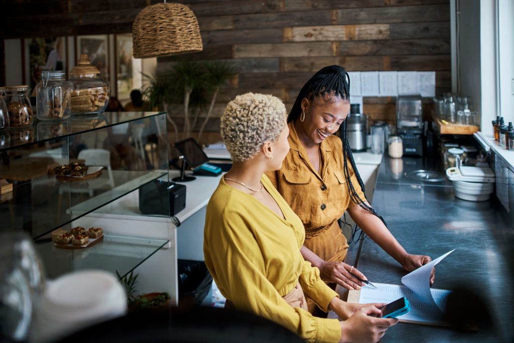 Small business owners talking and discussing the performance of their coffee shop. - HospitalityLawyer.com®