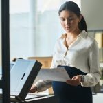 Young pregnant secretary using xerox - HospitalityLawyer.com®