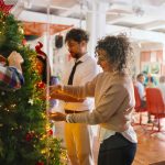 Beautiful businesswoman decorating the office with her colleagues - HospitalityLawyer.com®