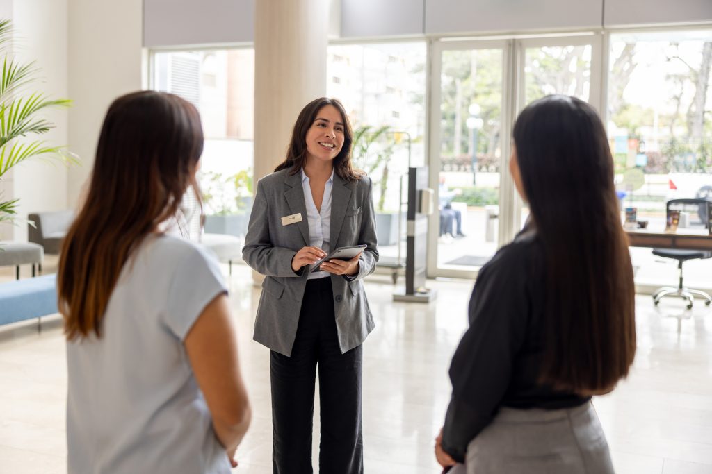 Hotel manager talking to a couple of employees at the lobby - HospitalityLawyer.com®