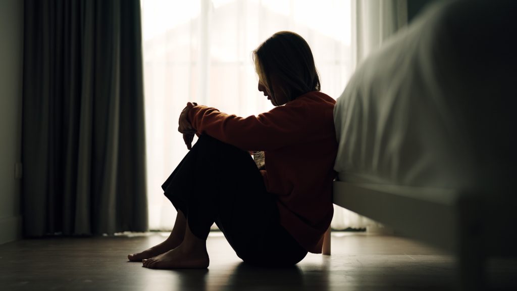Woman depression in bedroom - HospitalityLawyer.com®